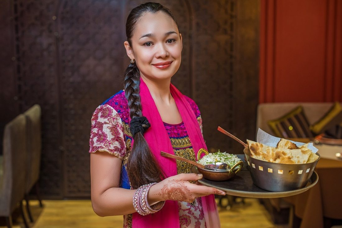 Официантка Tandoor с подносом блюд